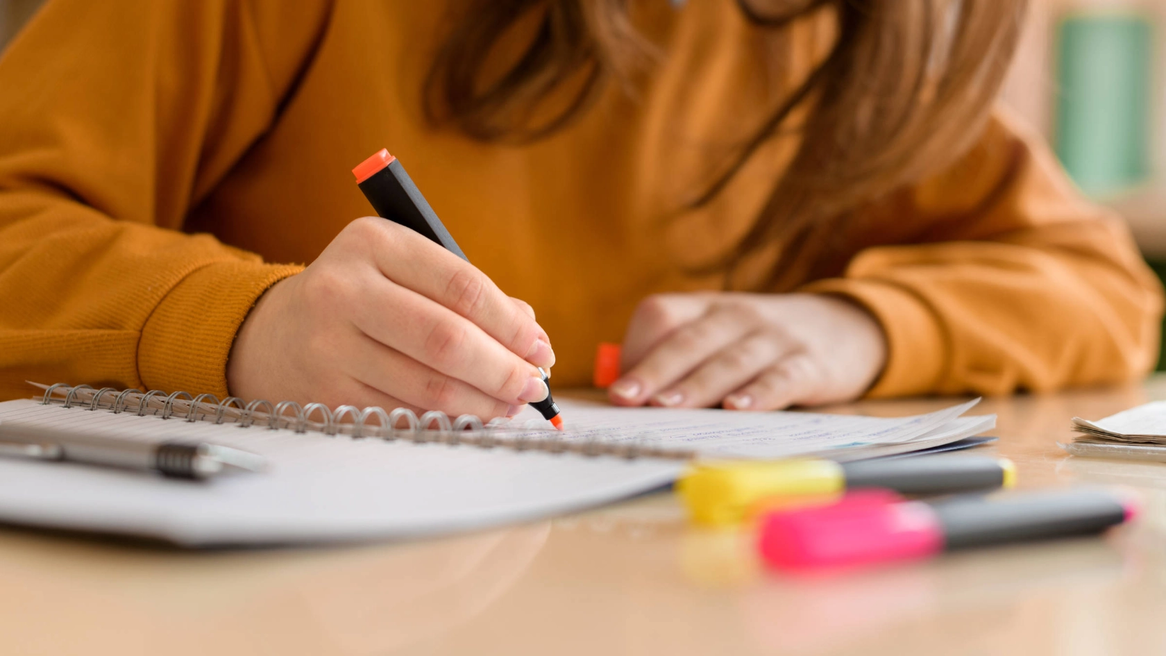 Jemand streicht mit einem Textmarker etwas auf einem Block an.