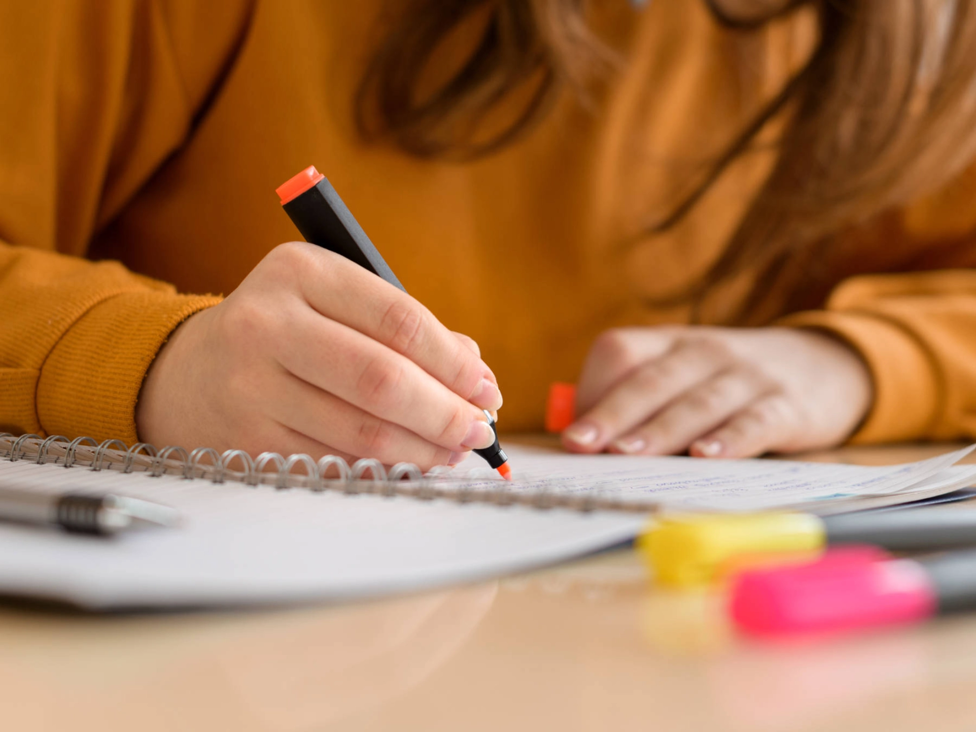 Jemand streicht mit einem Textmarker etwas auf einem Block an.